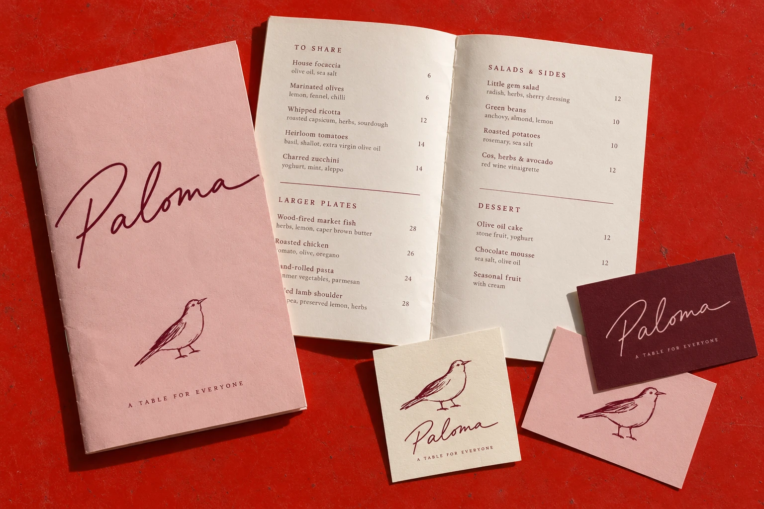 Paloma script logo on a pink menu booklet and restaurant business cards